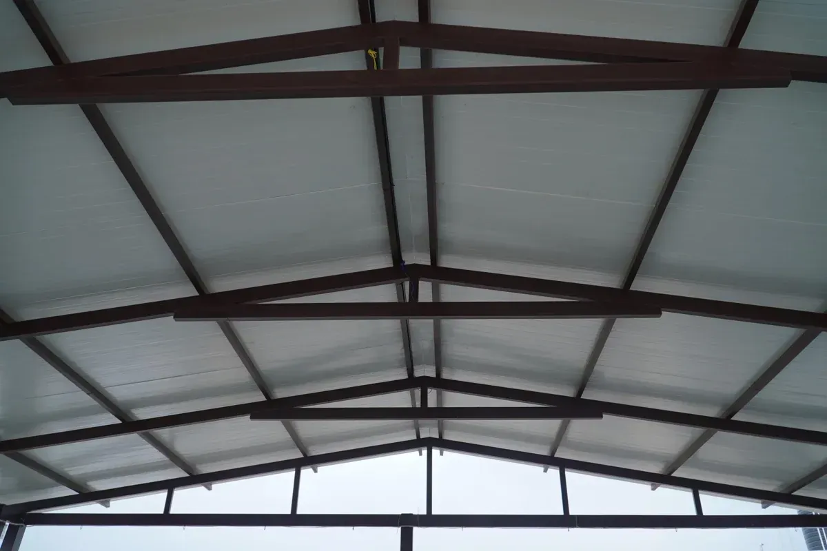 Interior view of an A-slope PUF pergola roof with two roof planes meeting above triangular steel trusses