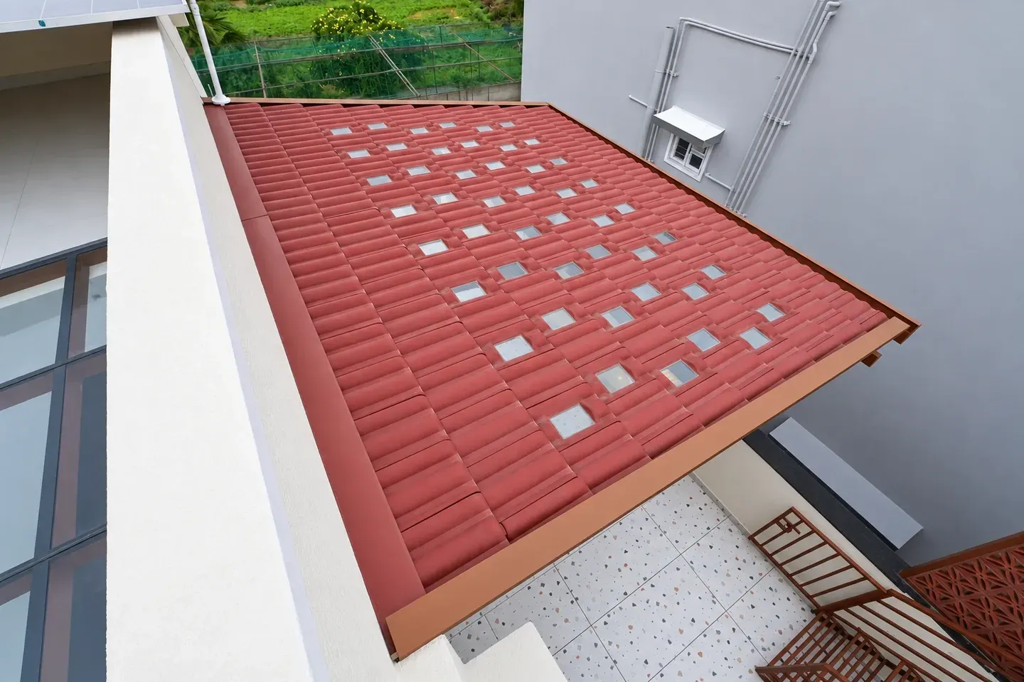 Overhead view of a red Mangalore tile roof with a regular grid of glass openings