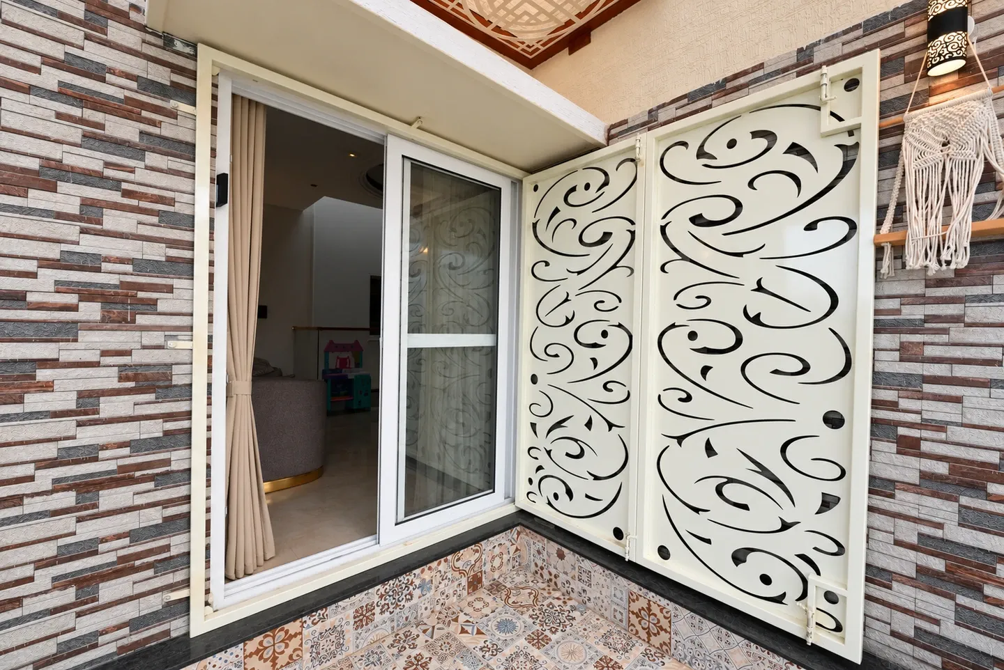 Open white decorative panel beside a sliding glass doorway on the terrace