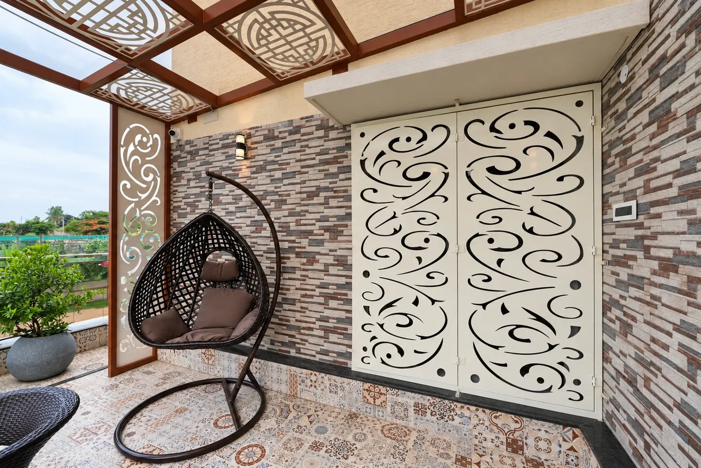 Hanging chair and white decorative panels beneath the terrace pergola