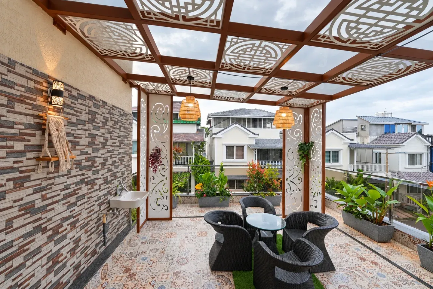 Wide view along the terrace with a table, chairs, hanging chair and patterned roof panels