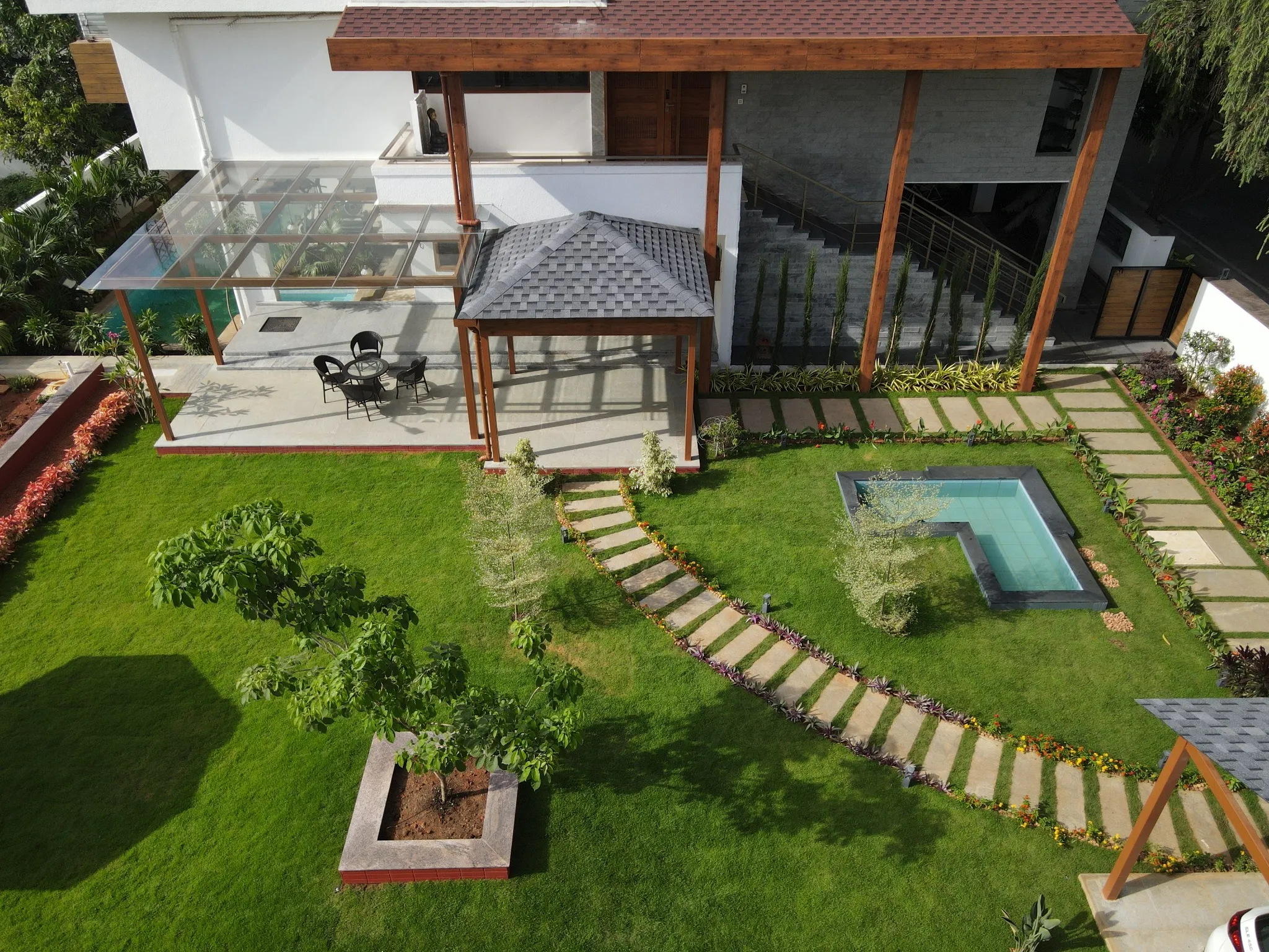 Aerial view of the completed glass and shingle pergolas with landscaped lawn and pathways
