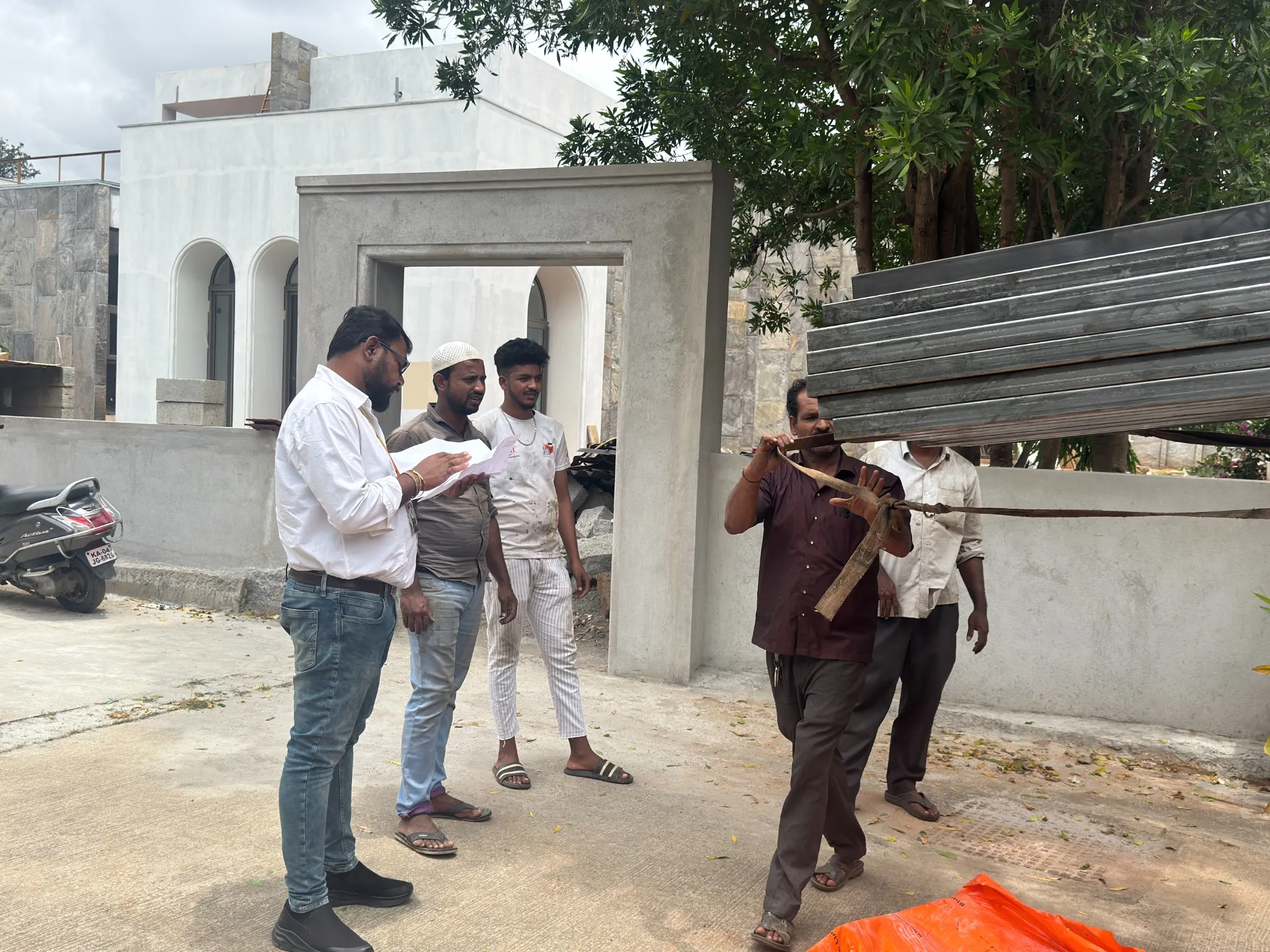 Team members discussing drawings and measurements at a project site