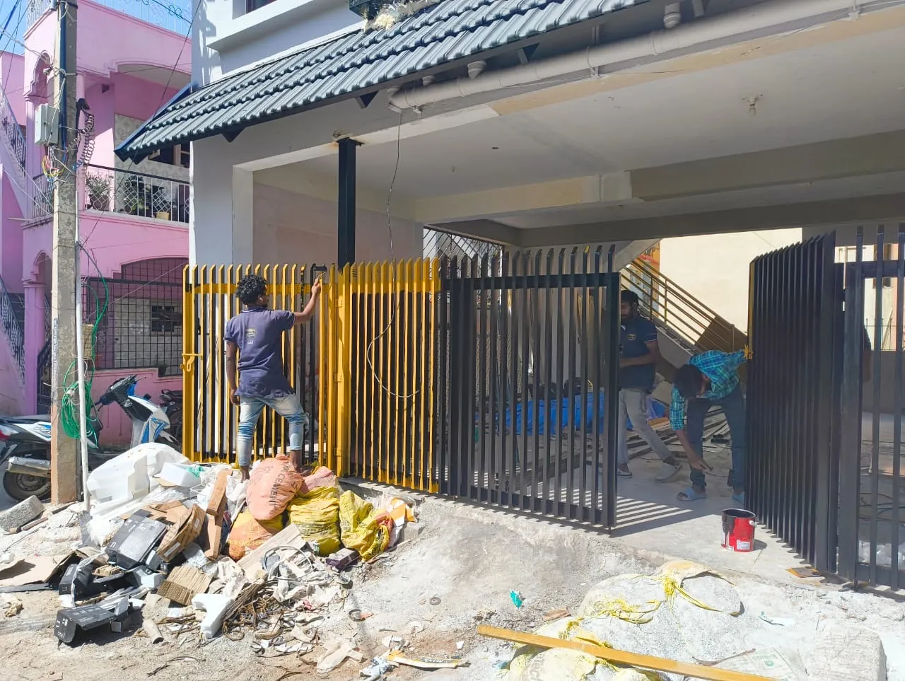 Fabricators installing a metal entrance gate at a house