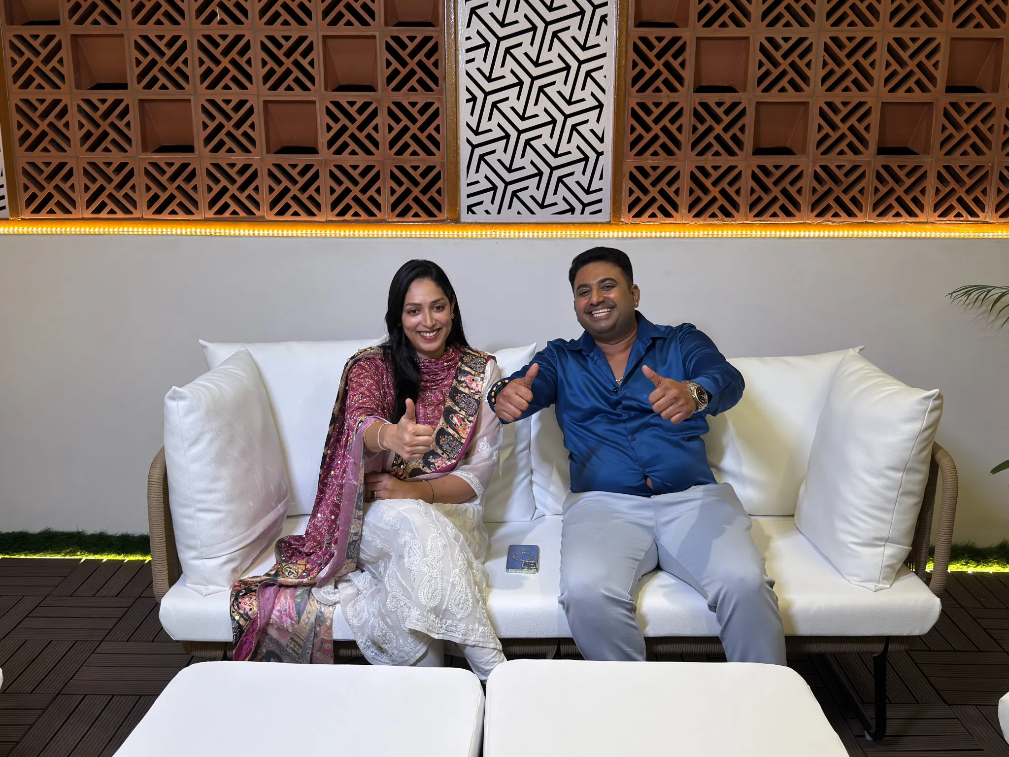 Customers relaxing in a seating area beside terracotta jali and decorative panels