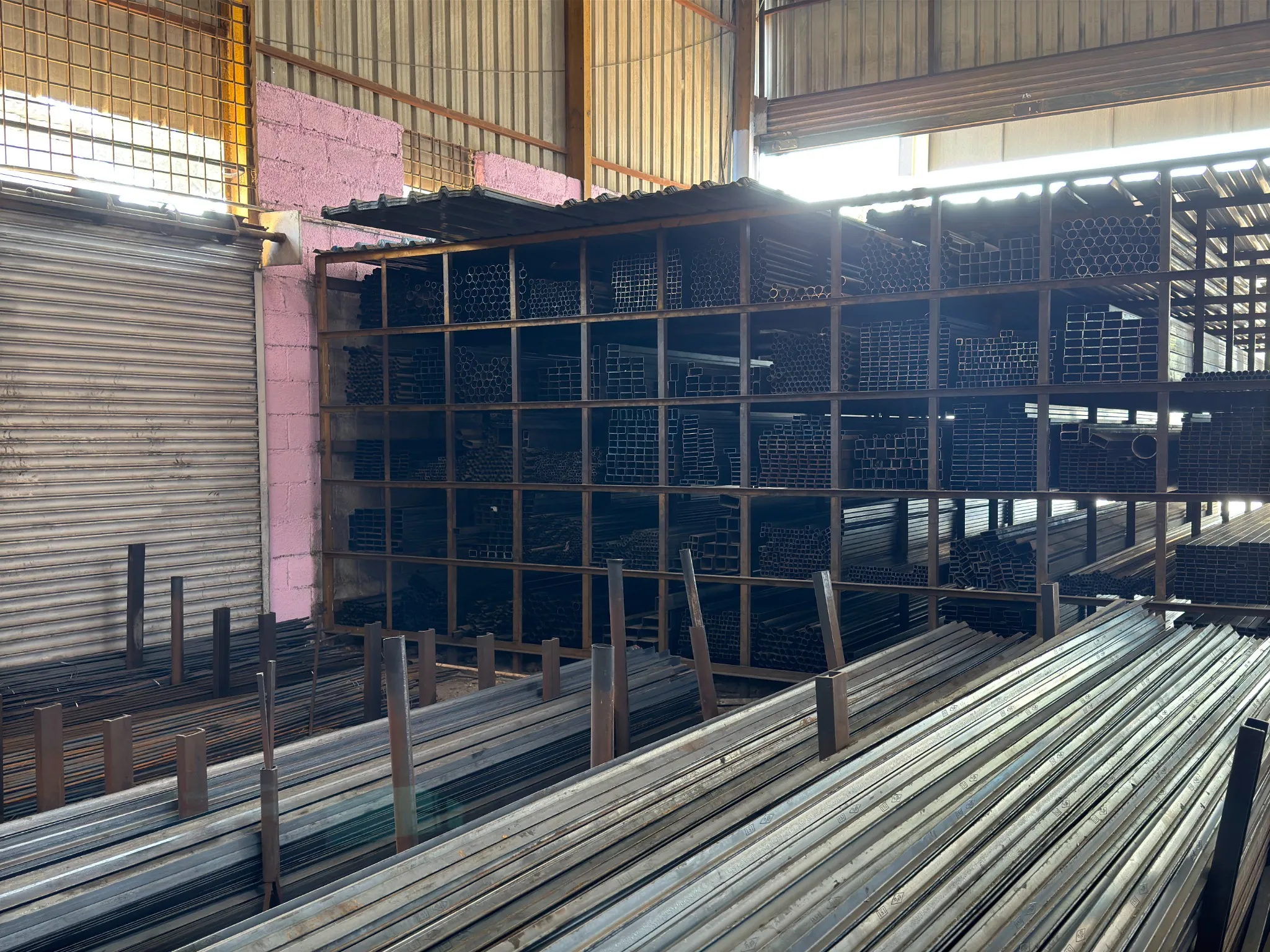 Steel sections and metal tubes stored inside a fabrication workshop