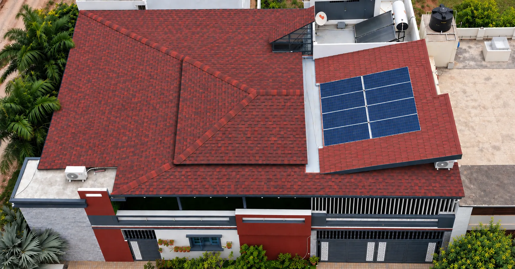 Completed red shingle roof with solar panels, viewed from above