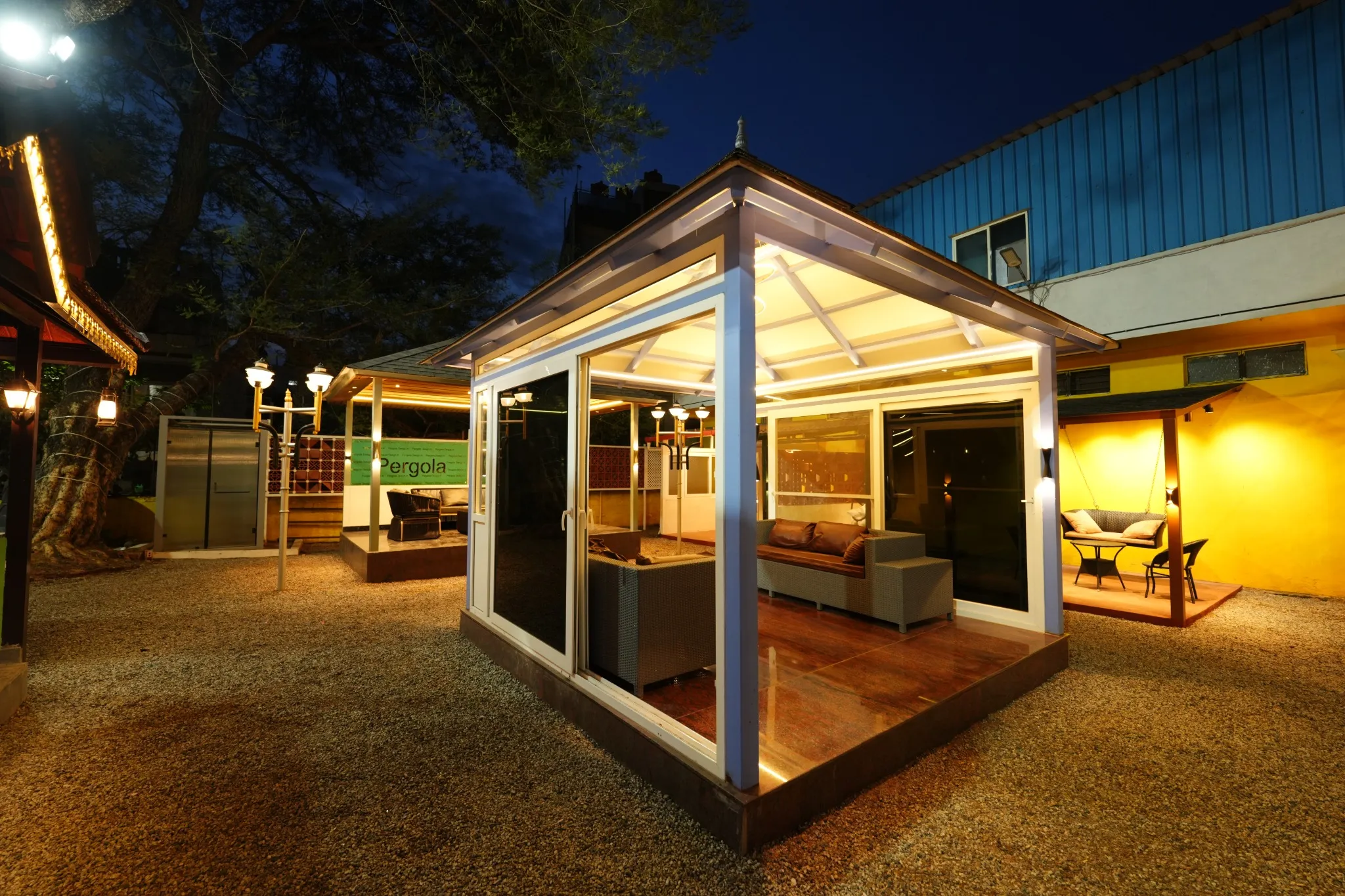 Exterior view of an illuminated glass-enclosed pergola display