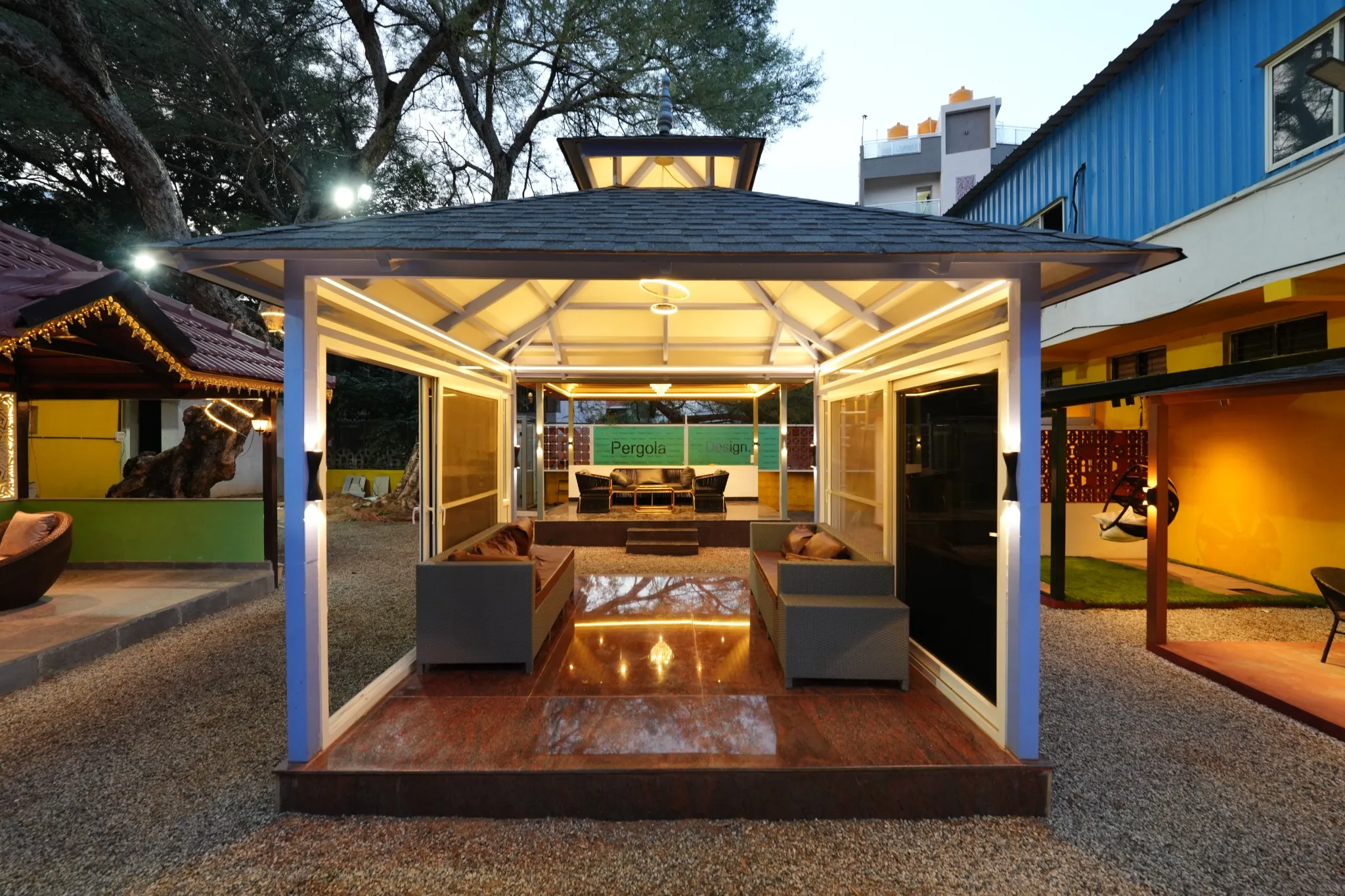 Glass-enclosed pergola seating display at dusk
