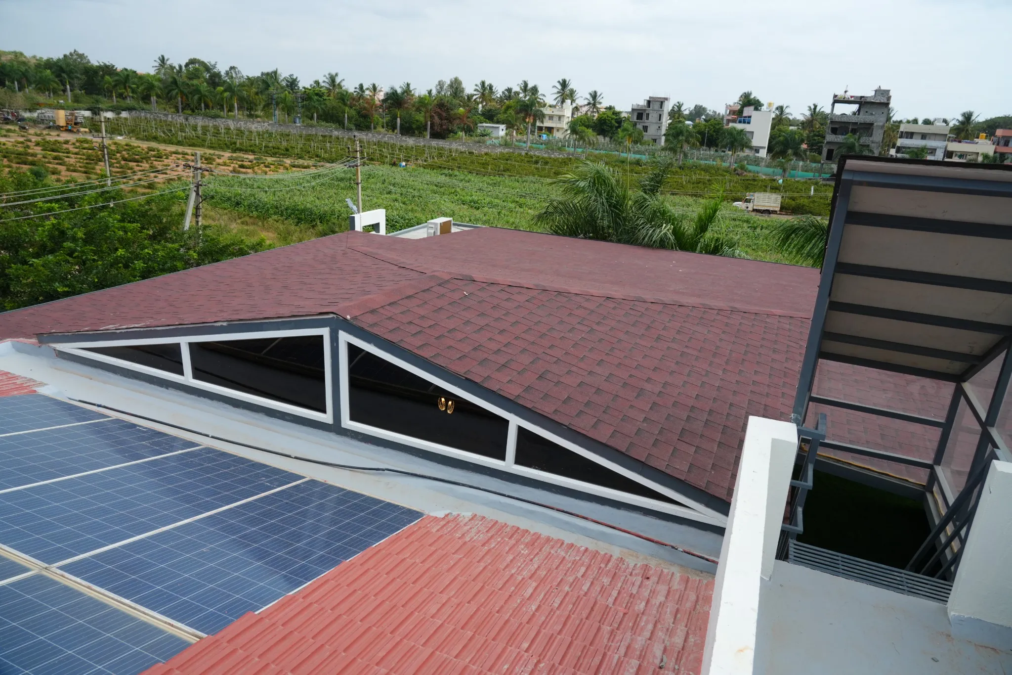 Completed shingle roof with glazed sections, viewed from a terrace