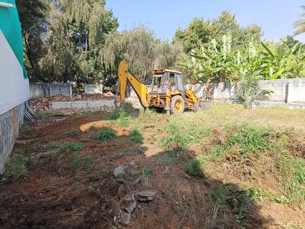 The open plot at the start of site preparation, with excavation equipment on site.