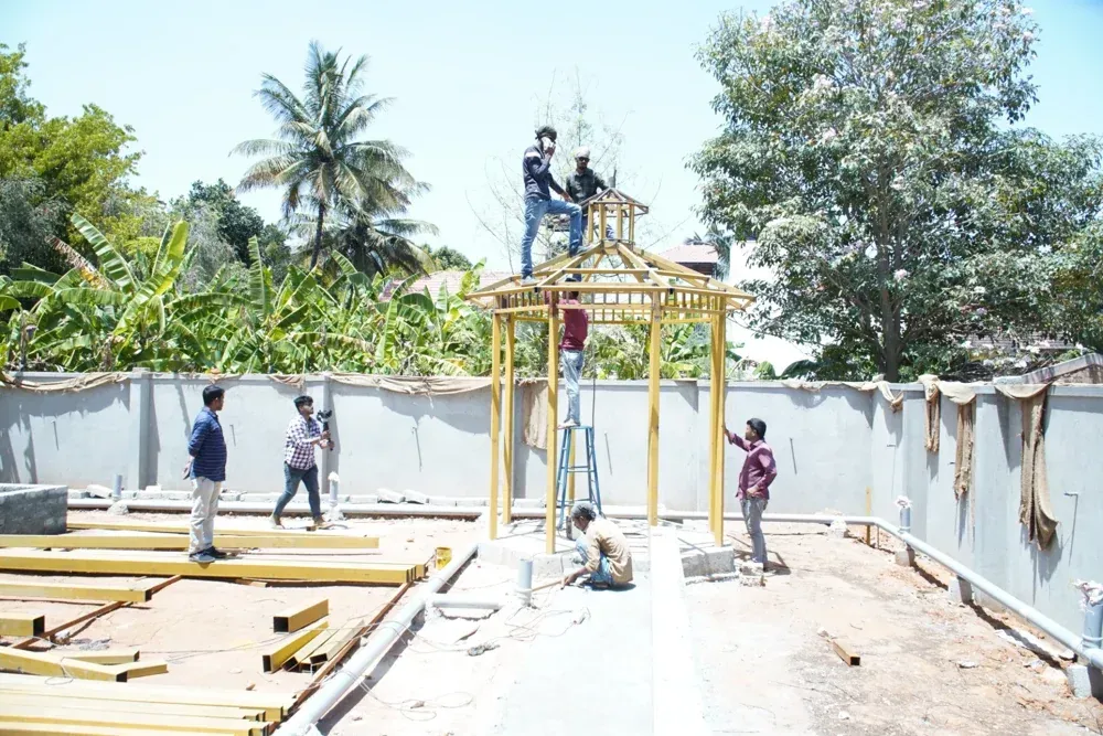 The team assembles the gazebo framework on site.
