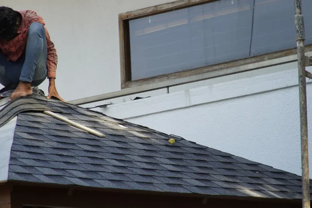A close view of the shingles being laid on the pitched roof.