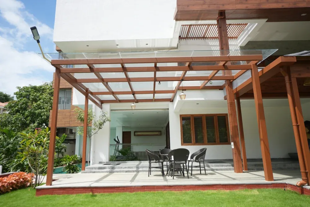 The finished glass pergola shelters the patio while keeping it open to daylight.