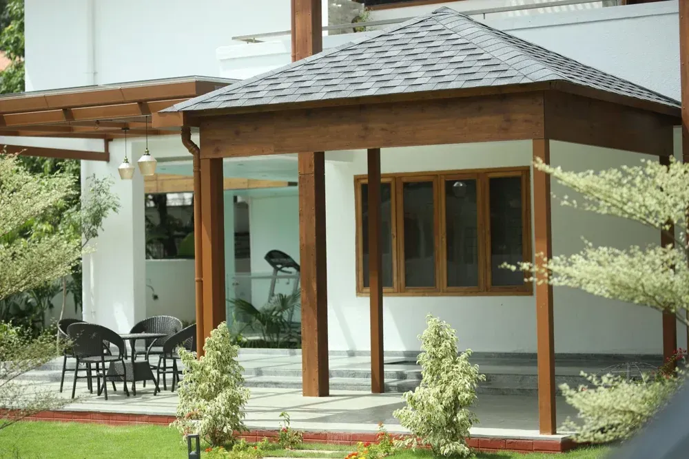 A pitched shingles roof and timber-toned frame define the entrance sit-out.