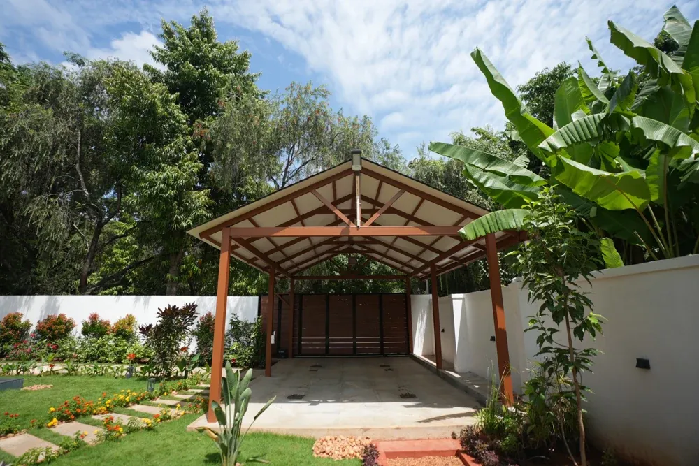 The gabled structure provides a covered parking space beside the garden.