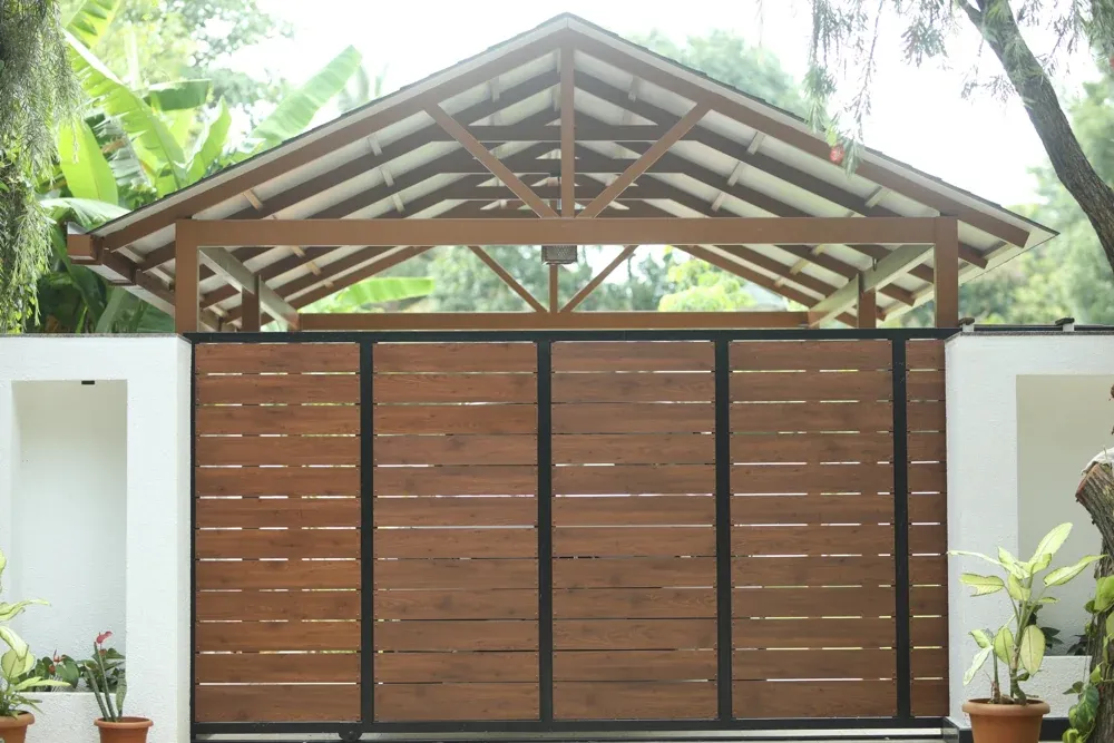 The main gate and car porch share a coordinated timber-toned finish.