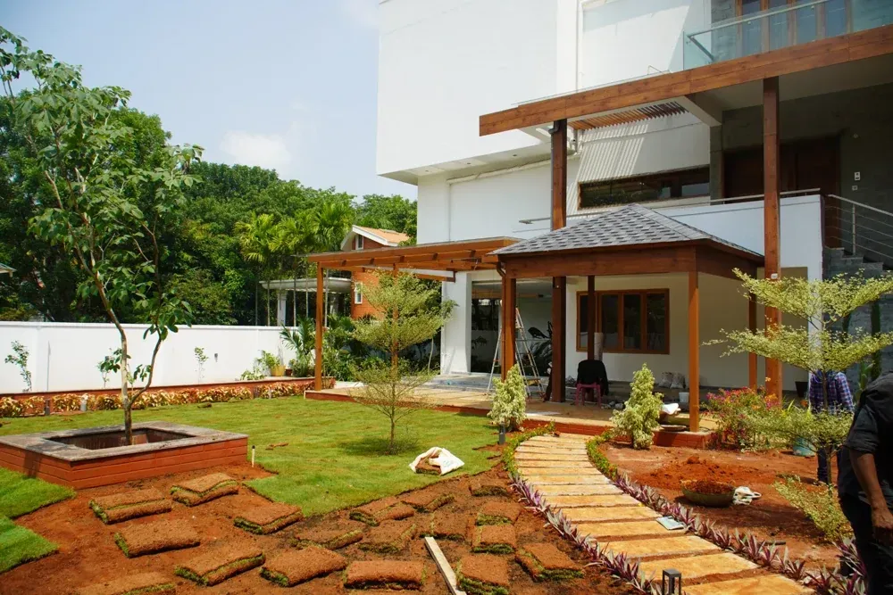 Lawn and curved pathways are installed around the finished structures.
