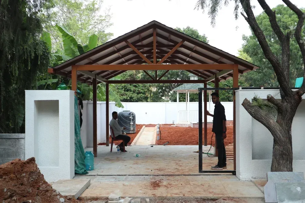 The car porch frame takes shape while the surrounding ground is still being prepared.