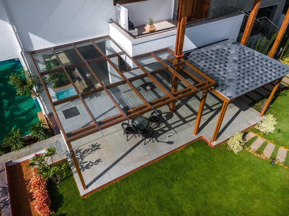 A closer aerial view shows the glass pergola beside the pitched shingles roof.