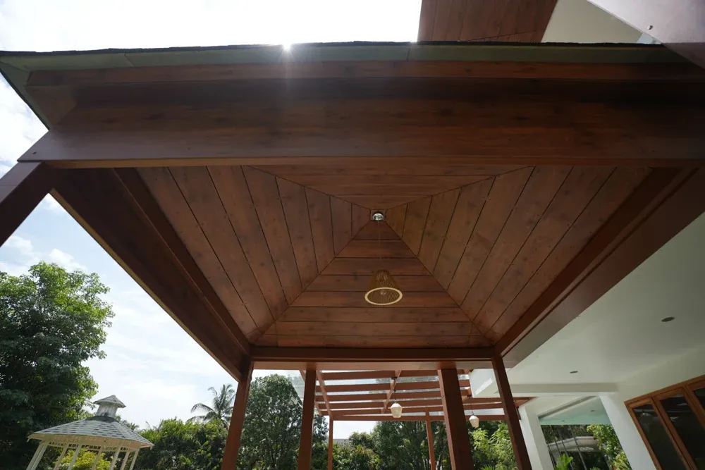 A close view of the timber-toned ceiling and recessed lighting beneath the pitched roof.
