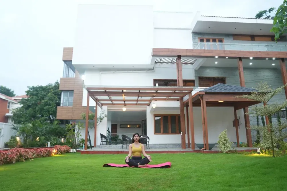 A yoga moment on the lawn with the completed pergolas and home in the background.