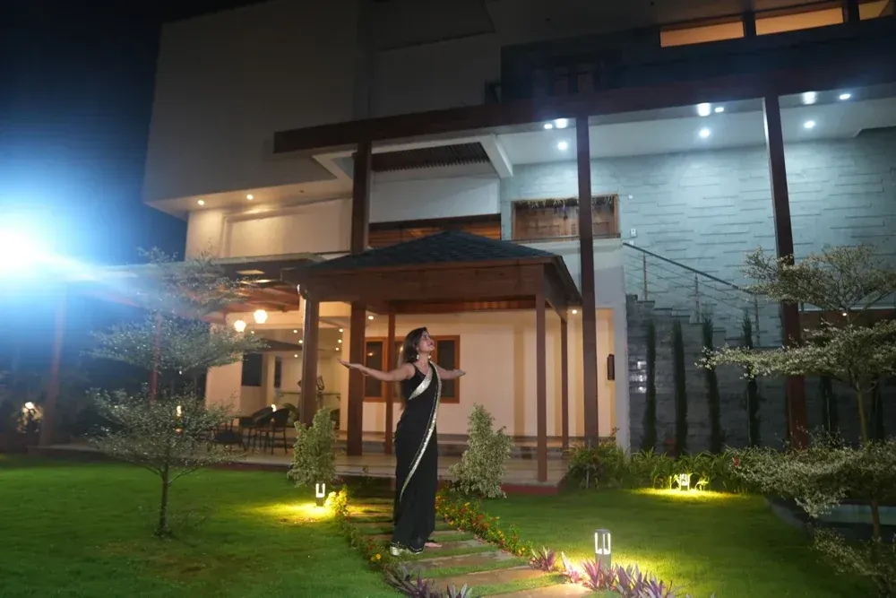 An evening view captures the illuminated house, covered spaces and garden during an on-site shoot.