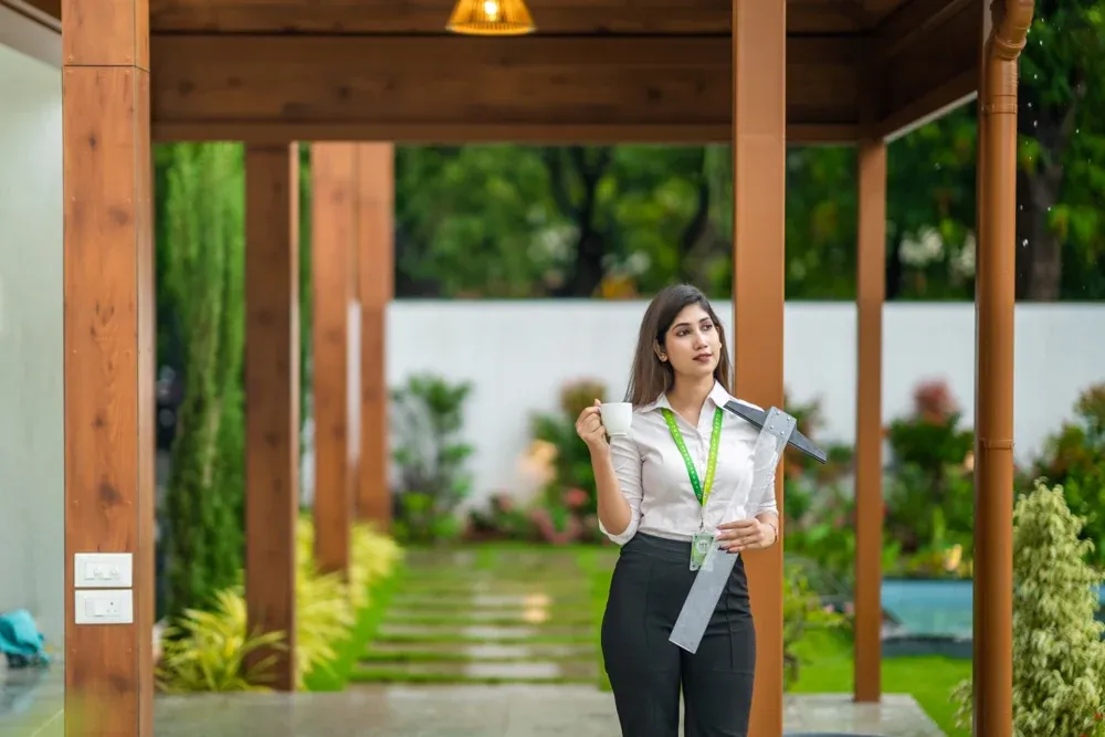 A presenter speaks beside the timber-toned entrance structure.