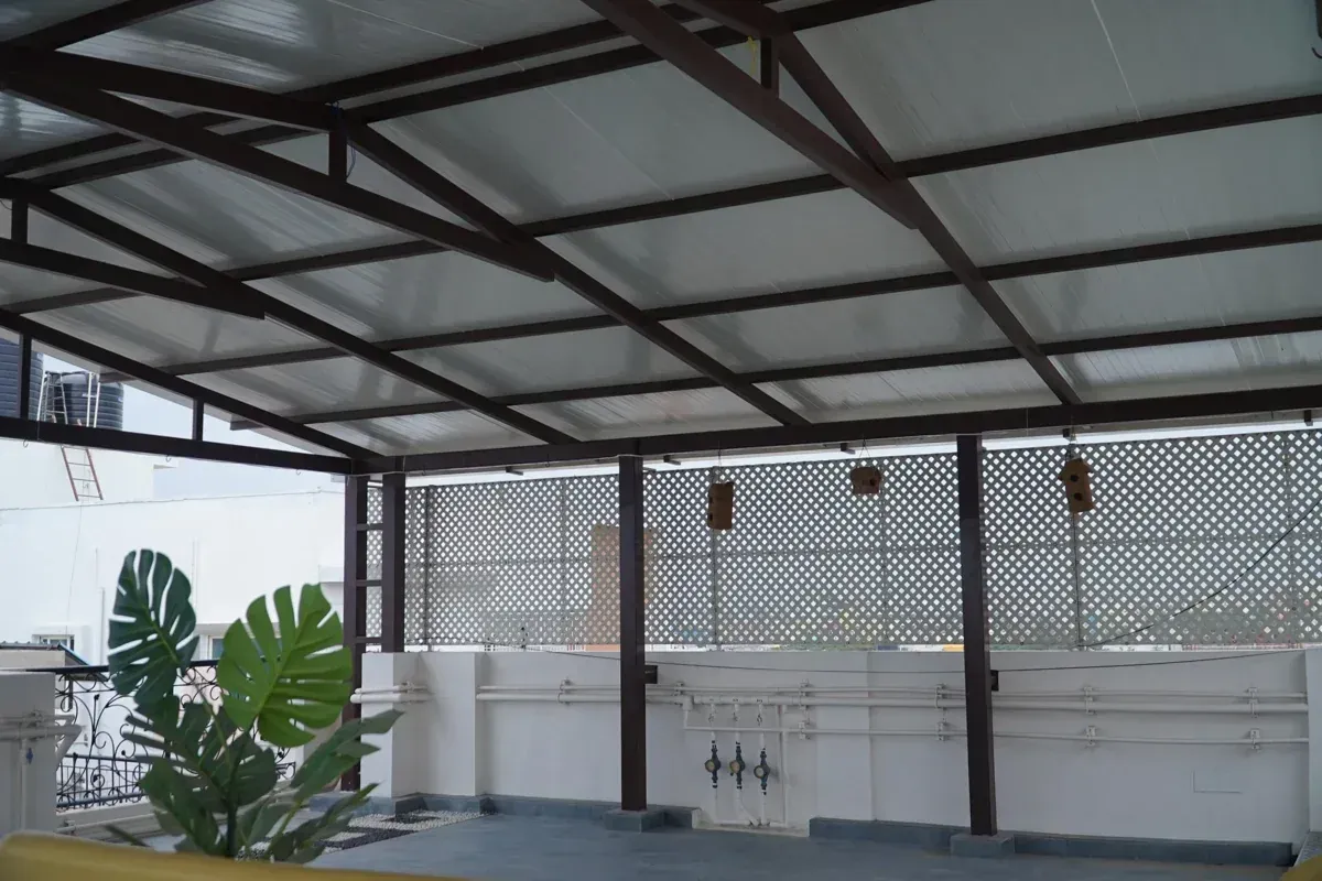 Custom PUF pergola with aligned metal beams, white roofing panels and patterned privacy panels