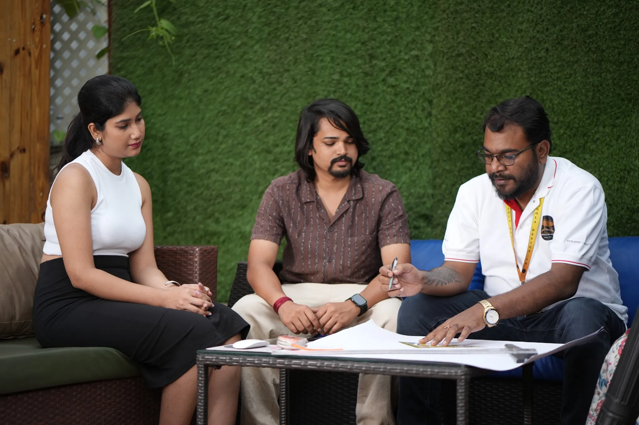 Pergola Design.in team reviewing design plans with customers during a consultation