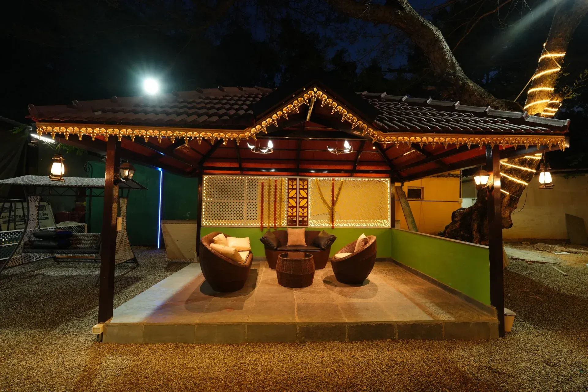 Tiled garden pavilion with lounge chairs and warm roof lighting