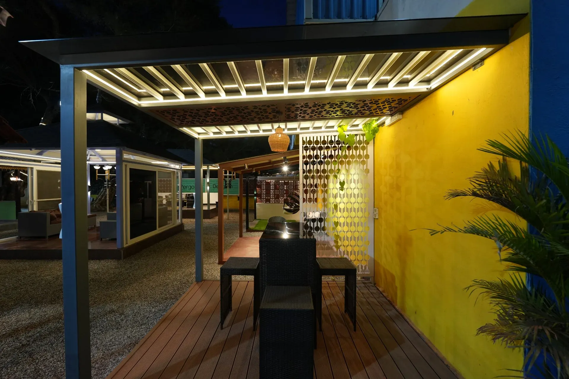 Premium Pergola display with dining furniture and illuminated roof rafters