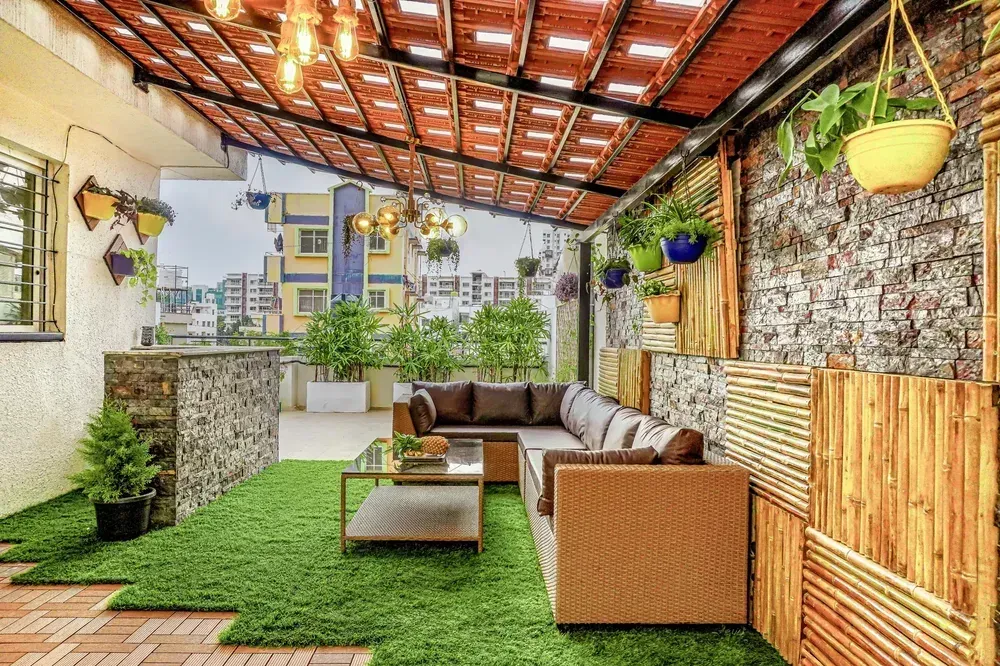 Terrace lounge beneath clay tiles and glass infill.