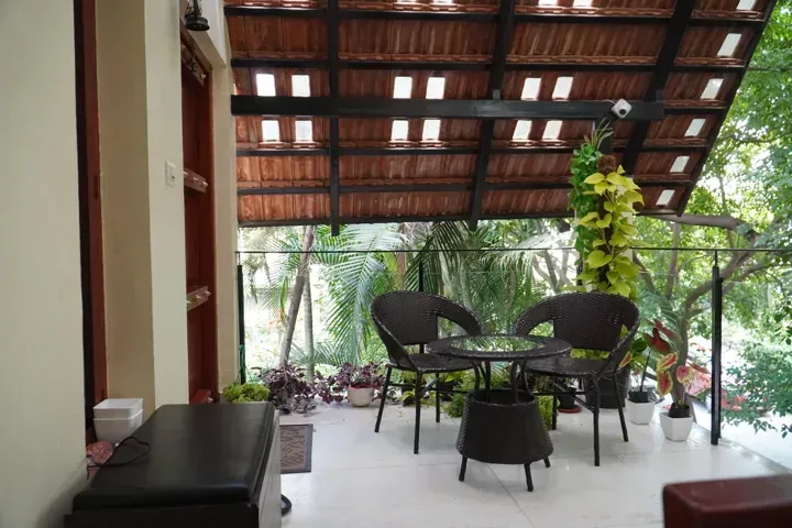 Garden patio seating beneath a clay-tile canopy with glass infill.