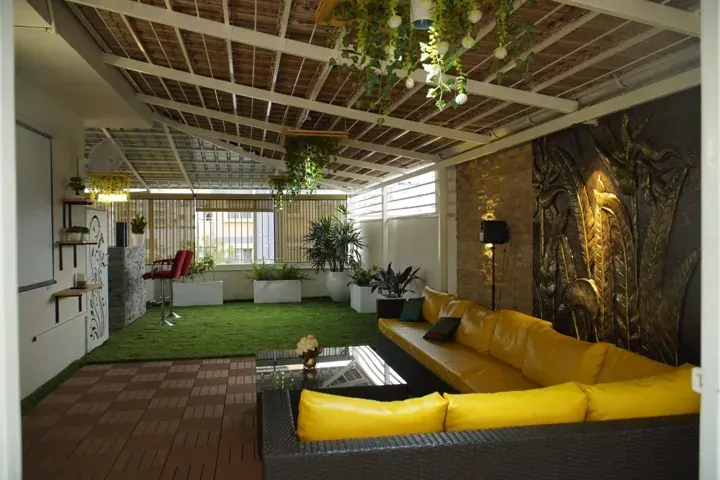 Covered lounge with exposed clay tiles and a white metal frame.