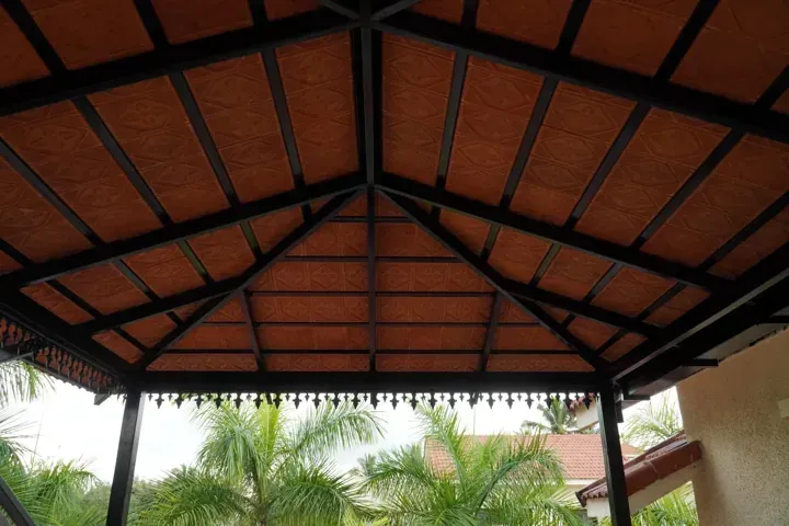 Pitched clay-tile canopy supported by a dark metal frame.