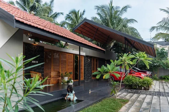 Red clay-tiled veranda beside a planted garden.