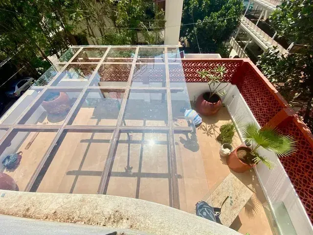 Overhead view showing the glass panes and supporting pergola grid