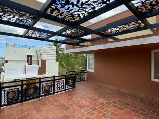 Glass pergola roof with decorative black panels above a tiled terrace