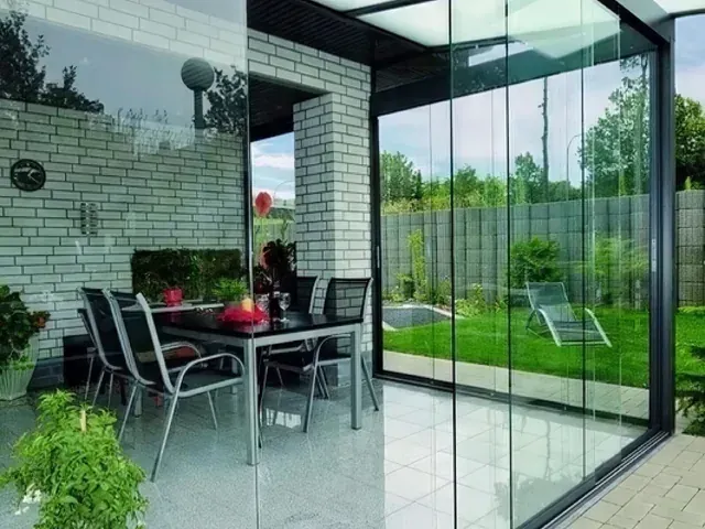 Garden-facing dining space enclosed by sliding glass panels