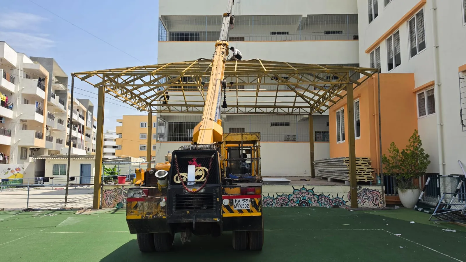 Crane assisting the installation of a large steel roof structure