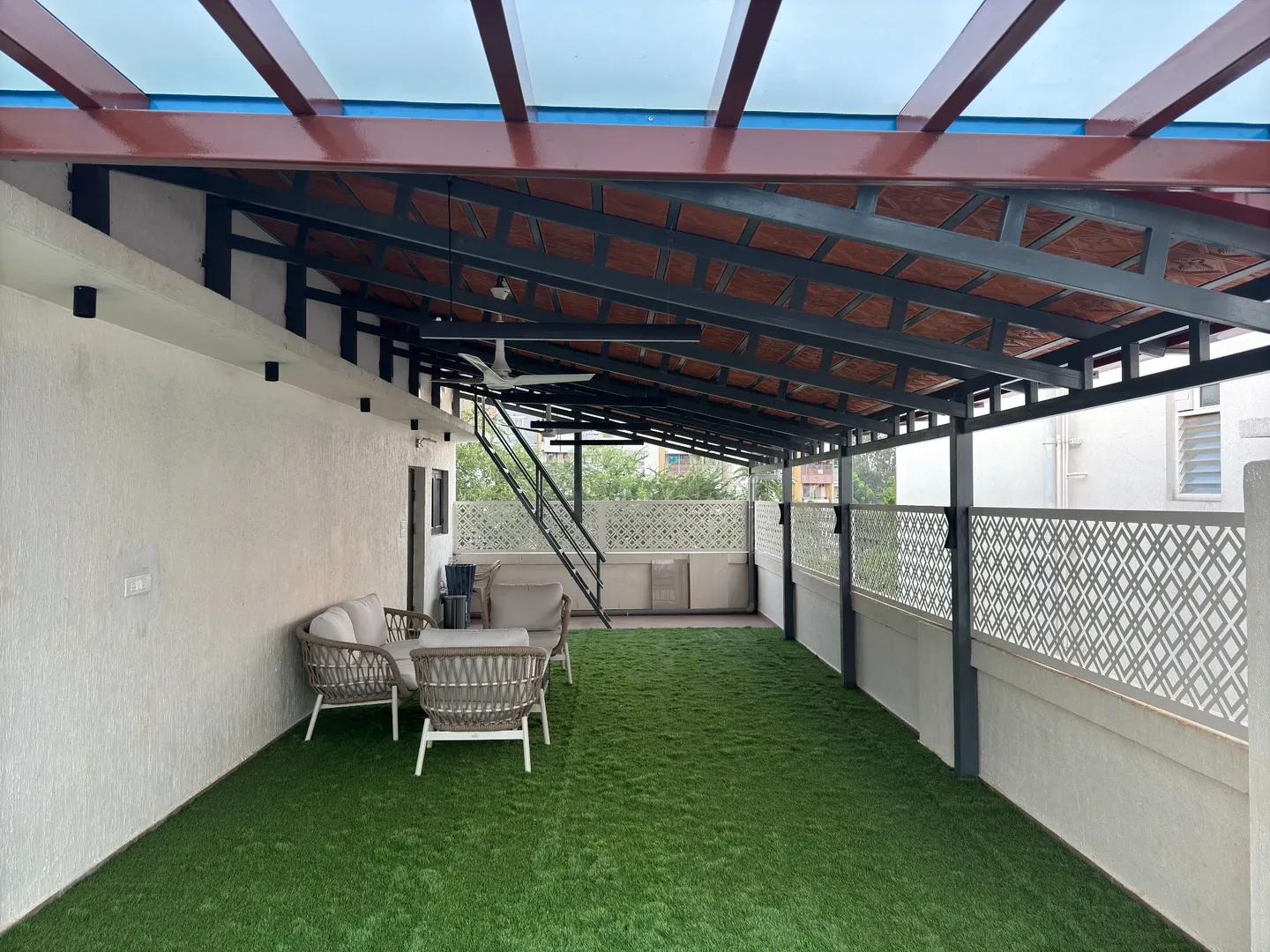 View along the terrace from the glazed roof to the tiled roof and staircase
