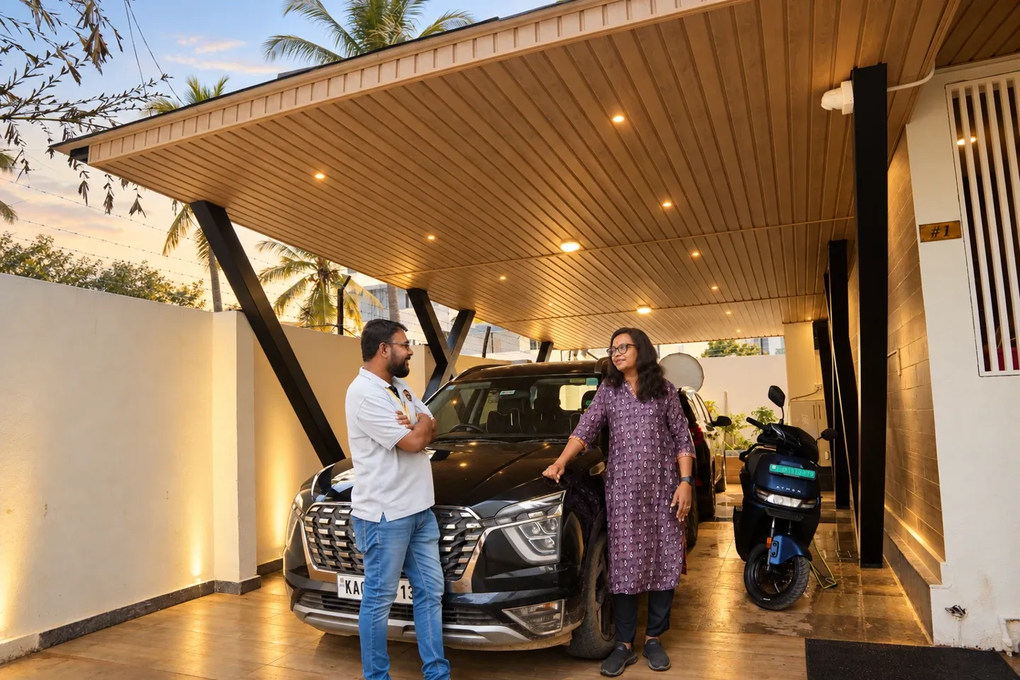 Enhanced view of two people beside a parked car beneath Jayashree’s illuminated pergola