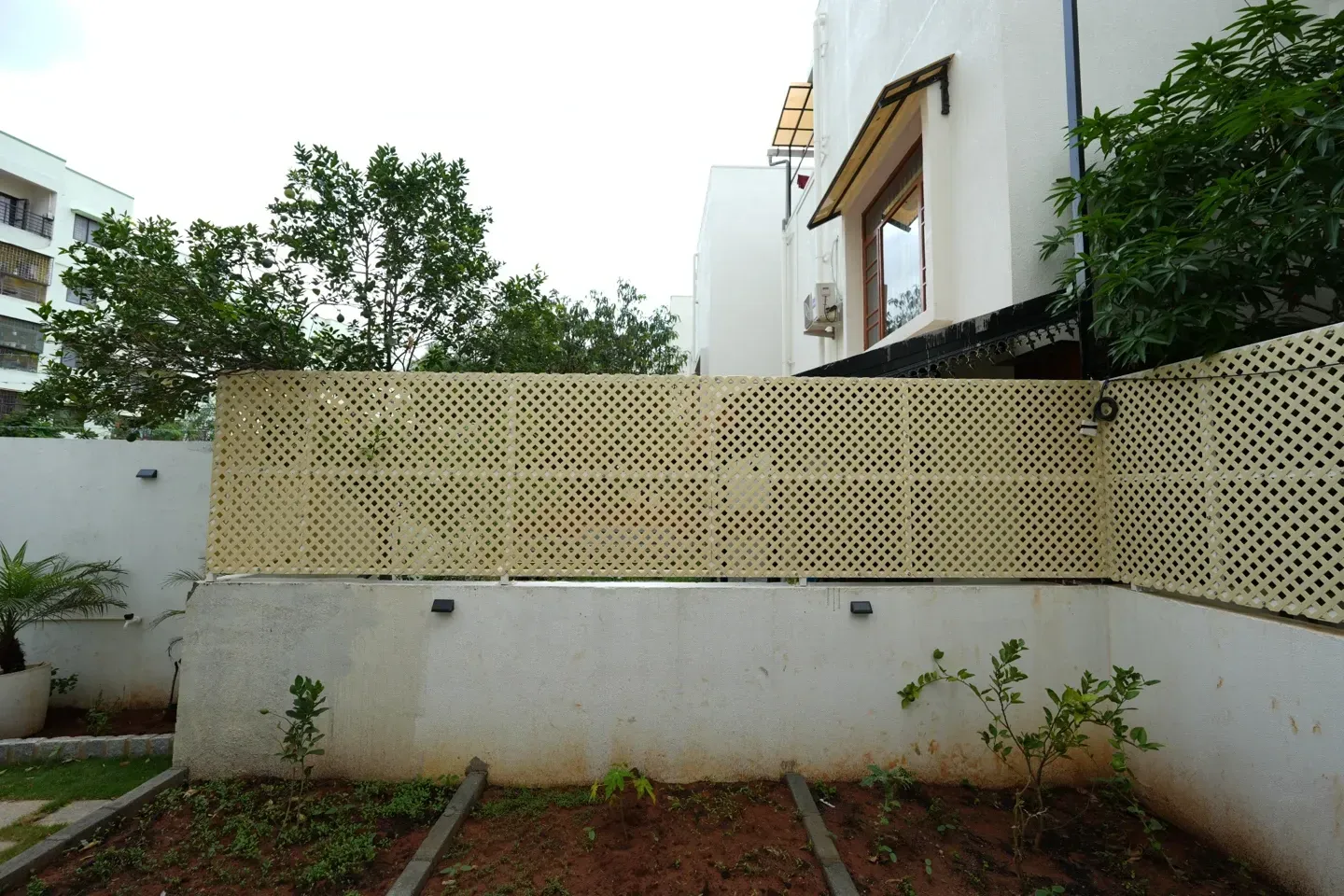 Wide view of pale lattice panels along the villa garden boundary wall