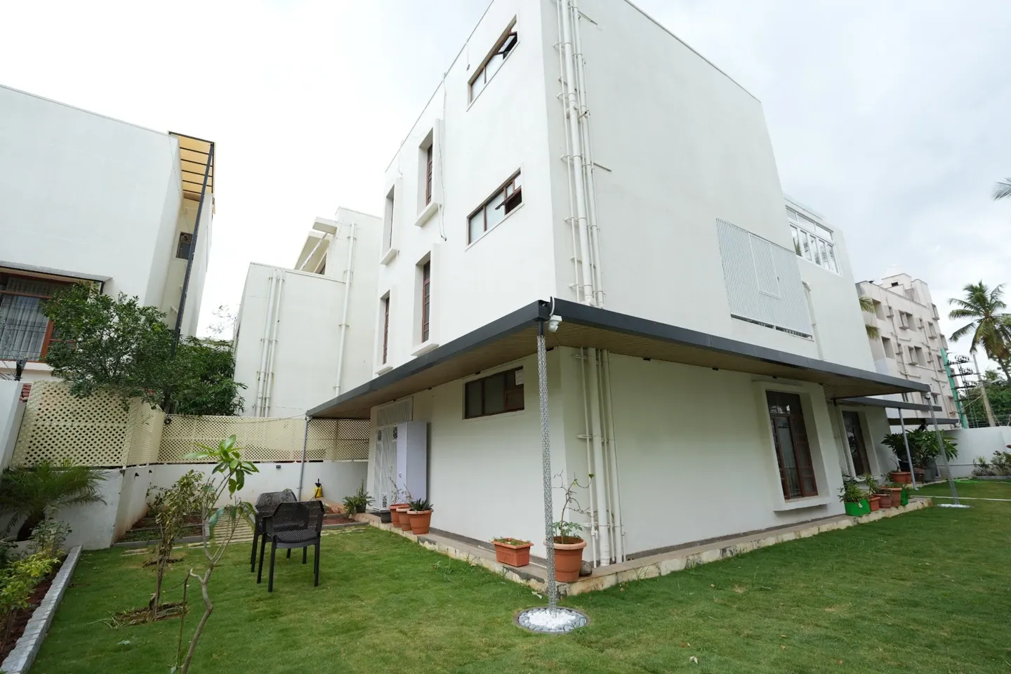 Wide view of Jayashree’s villa, wraparound canopy, garden lawn and lattice screens
