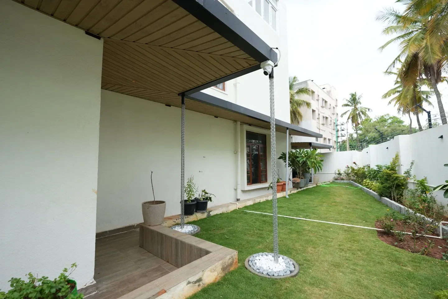 Side view of the covered entrance, rain chain and landscaped garden lawn