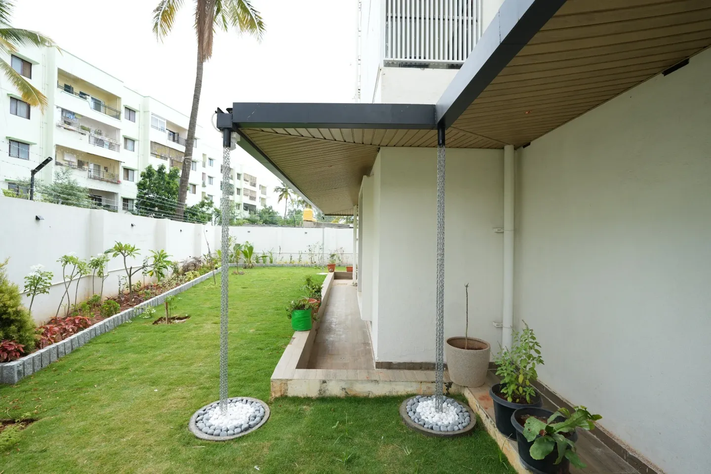 View of the canopy roofline, two rain chains and the garden beside the villa