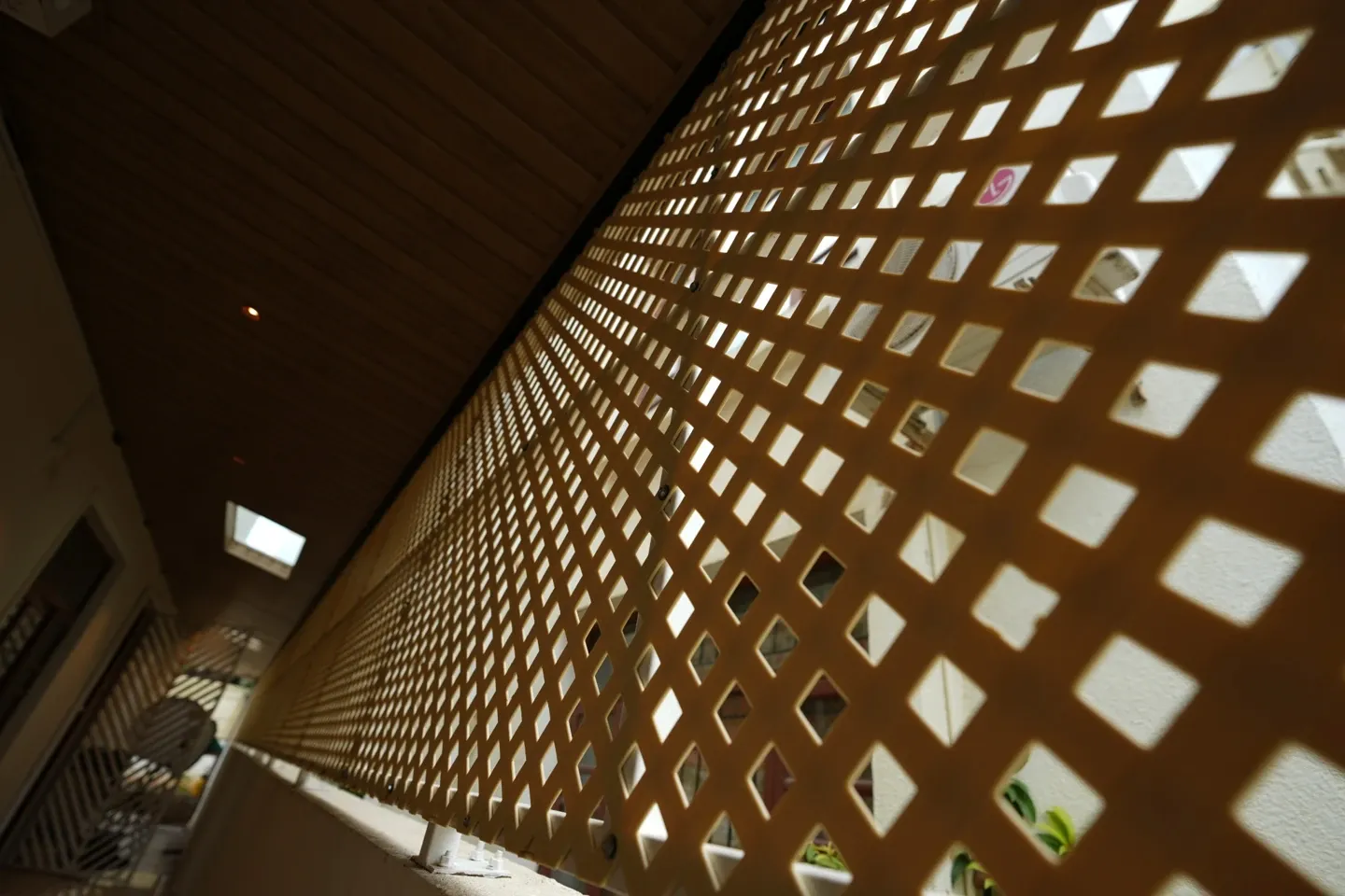 Angled close view of a lattice privacy panel along a covered passage
