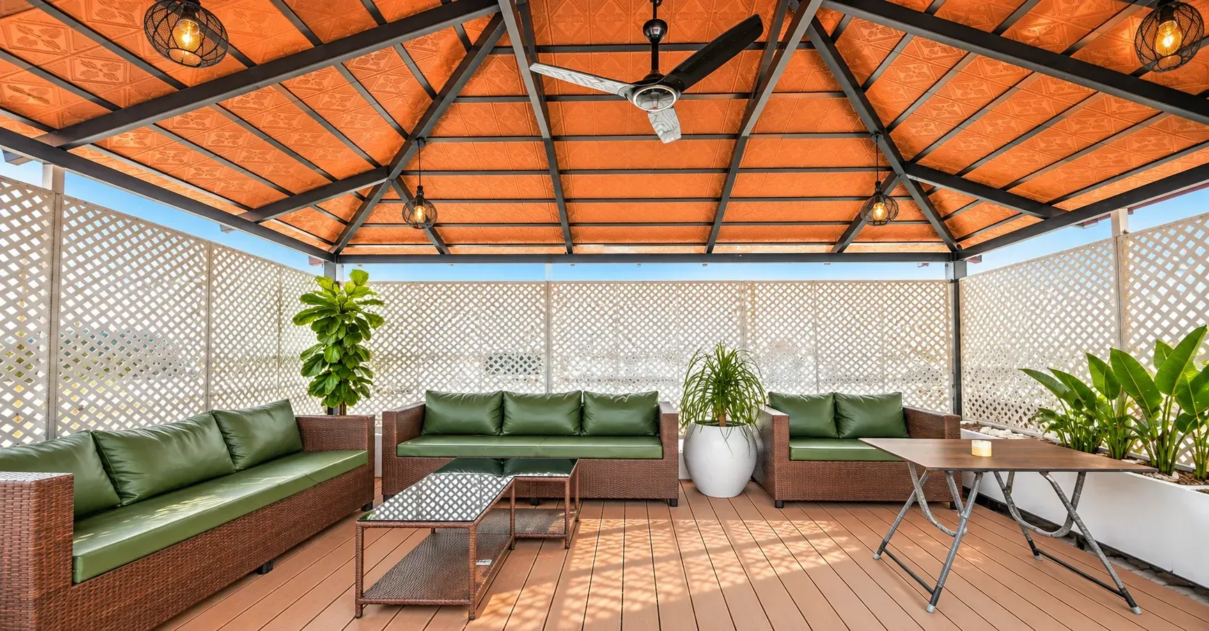 Mangalore tile pergola with a dark metal roof frame, white lattice privacy panels and green outdoor seating
