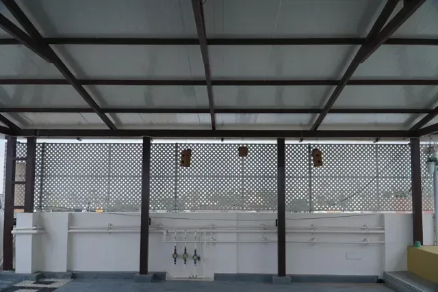 Covered terrace with patterned privacy panels beneath aligned roof beams
